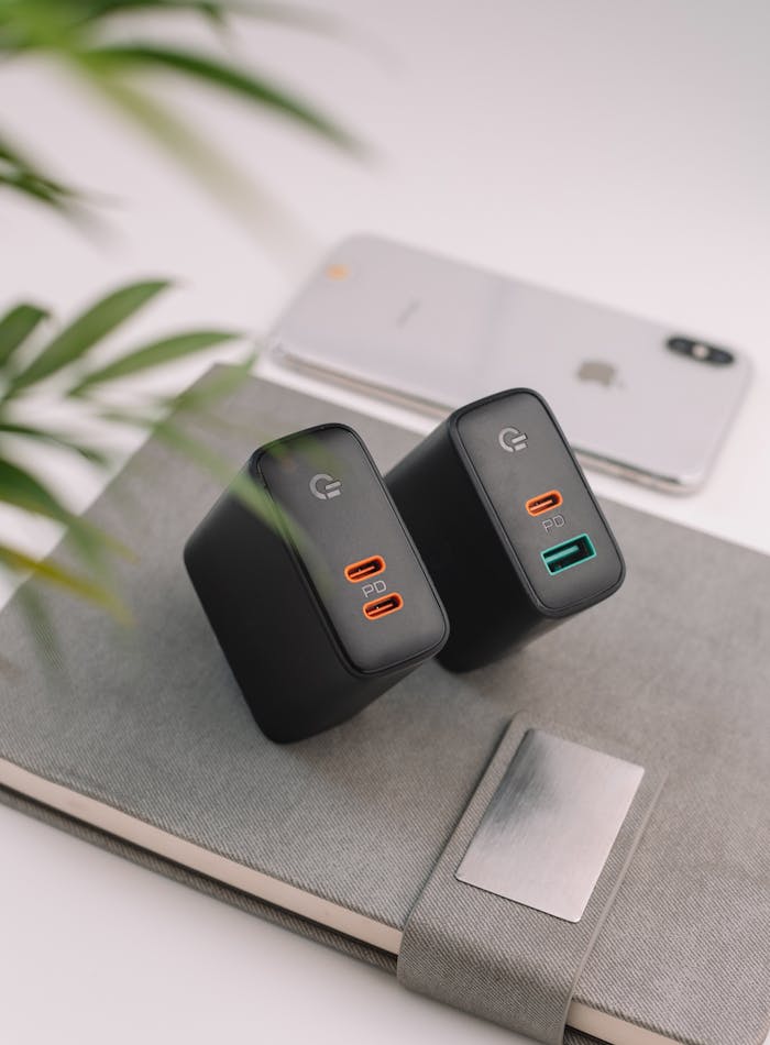 From above of power banks with notebook and modern mobile phone placed on white table